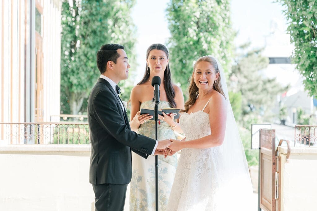 Katie laughs as she and Sang hold hands at the altar. 