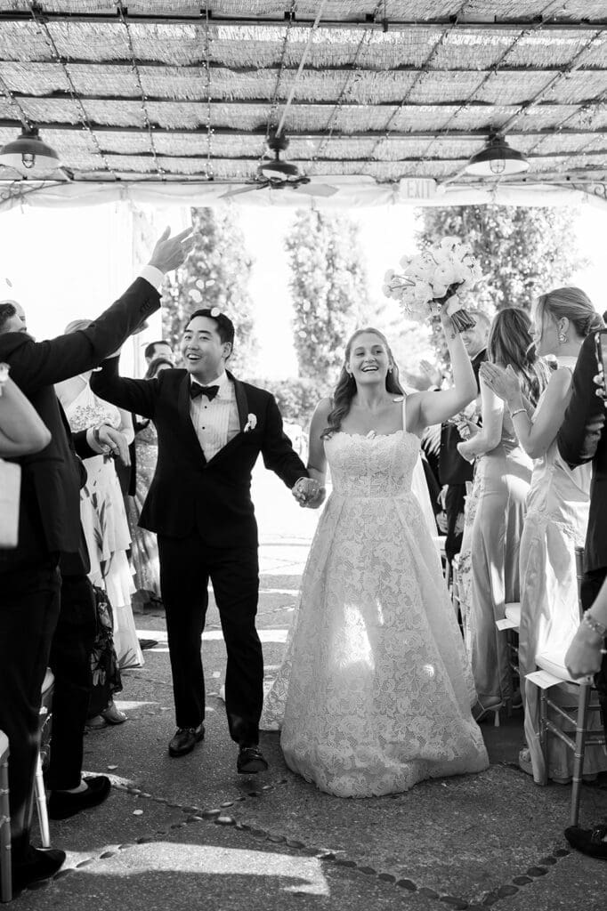 Sang and Katie cheer as everyone throws petals at them. 
