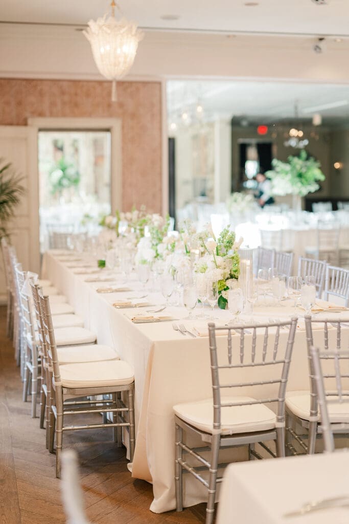 Green and white florals line the tables at their Delamar Greenwich wedding reception. 