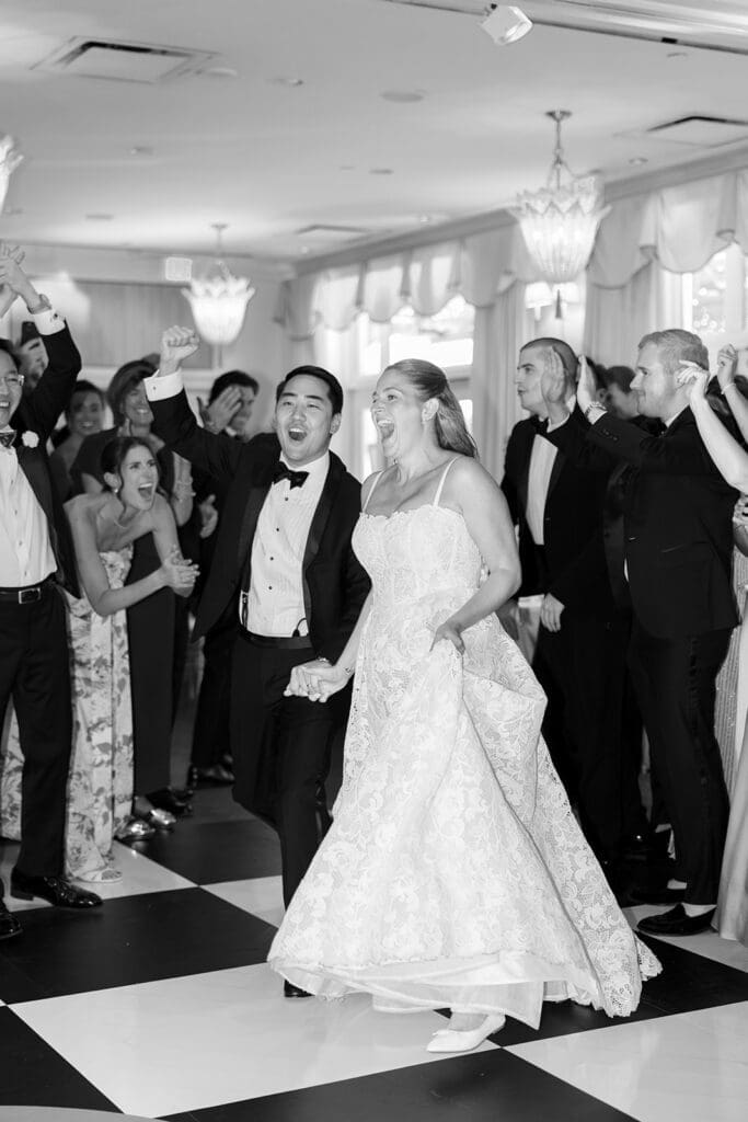 Katie and Sang cheer as they enter their wedding reception at Delamar Greenwich. 