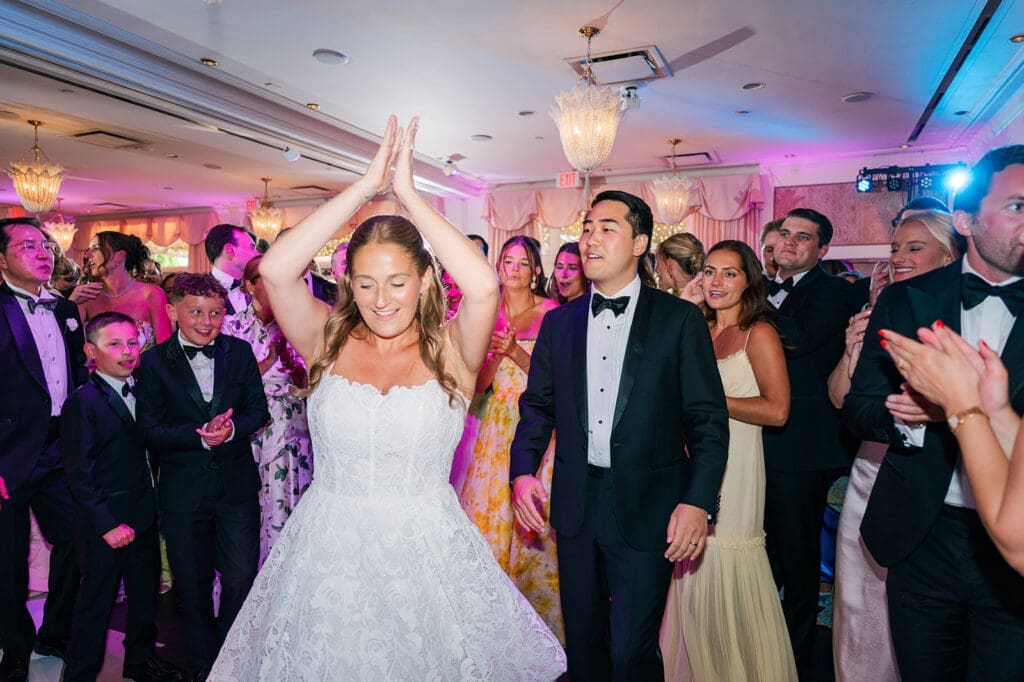Katie and Sang dance while their guests crowd around them.
