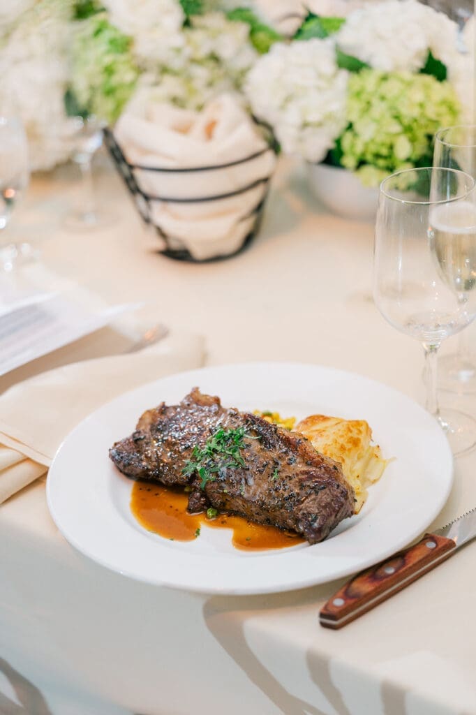 A large steak on a guest's dinner plate.