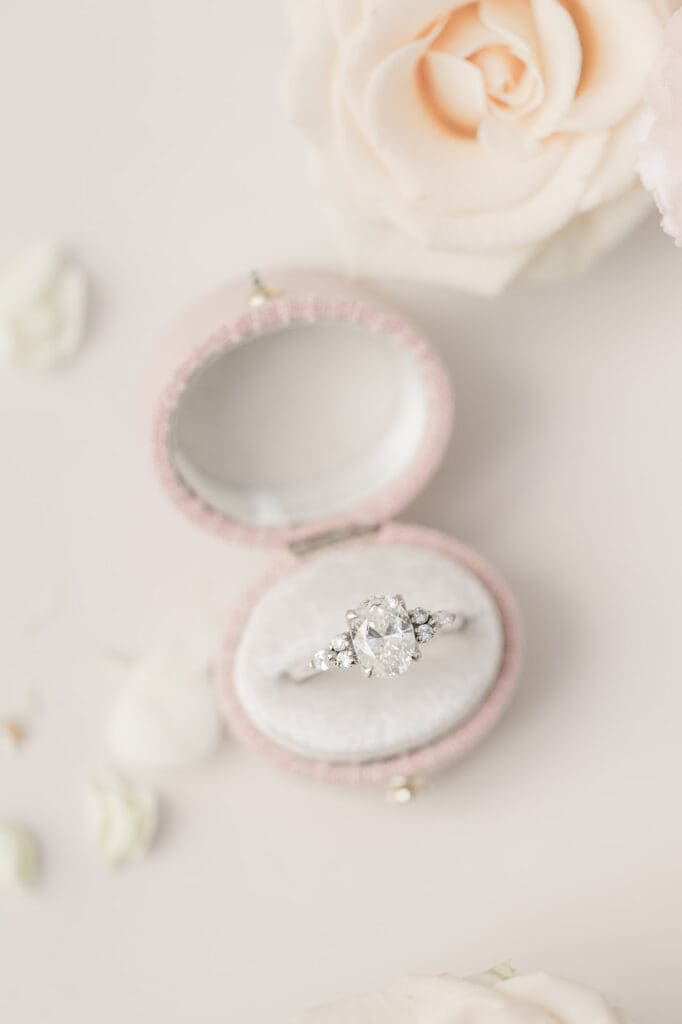 A macro photo of an oval diamond ring in an oval ring box