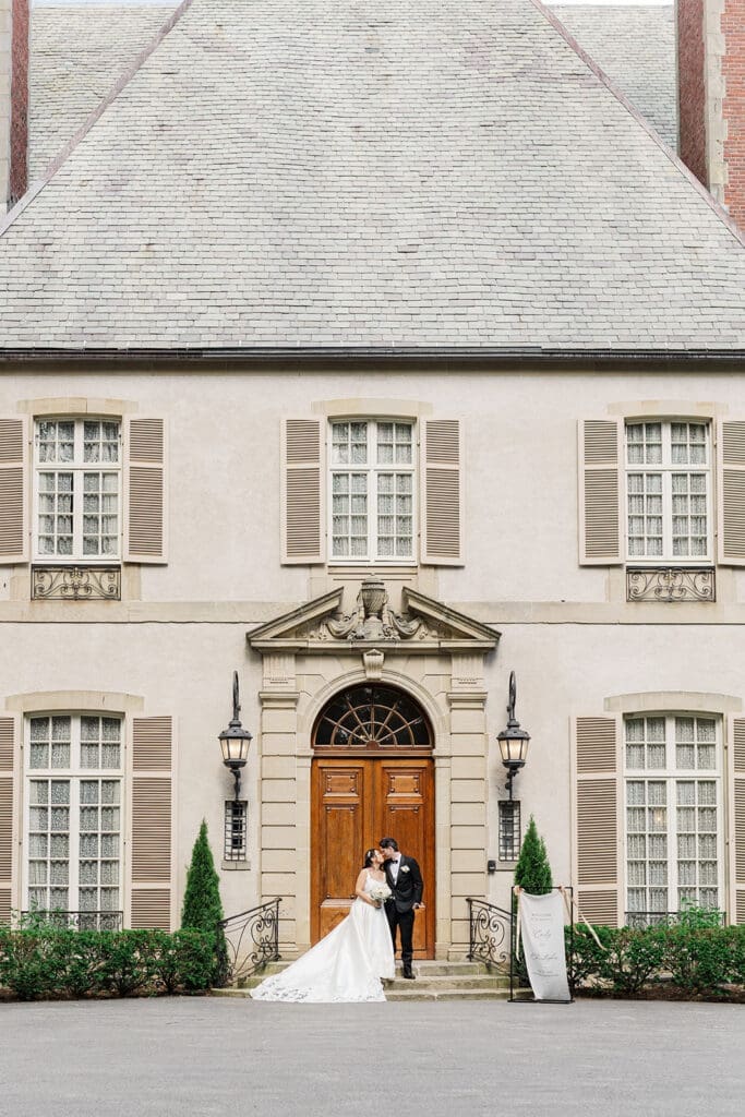 A couple kissing on the front steps of Glen Manor House. 