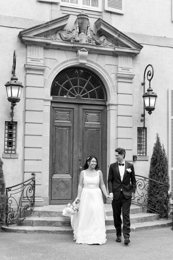 Emily and Chris smile as they walk together at Glen Manor House for their wedding 