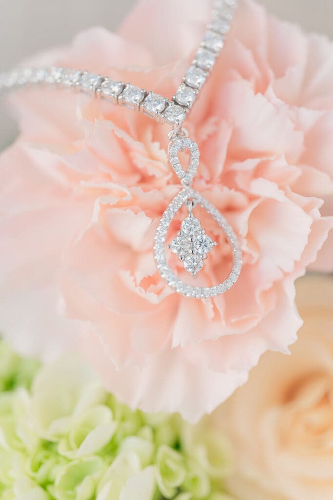 A macro photo of a diamond necklace on top of a flower