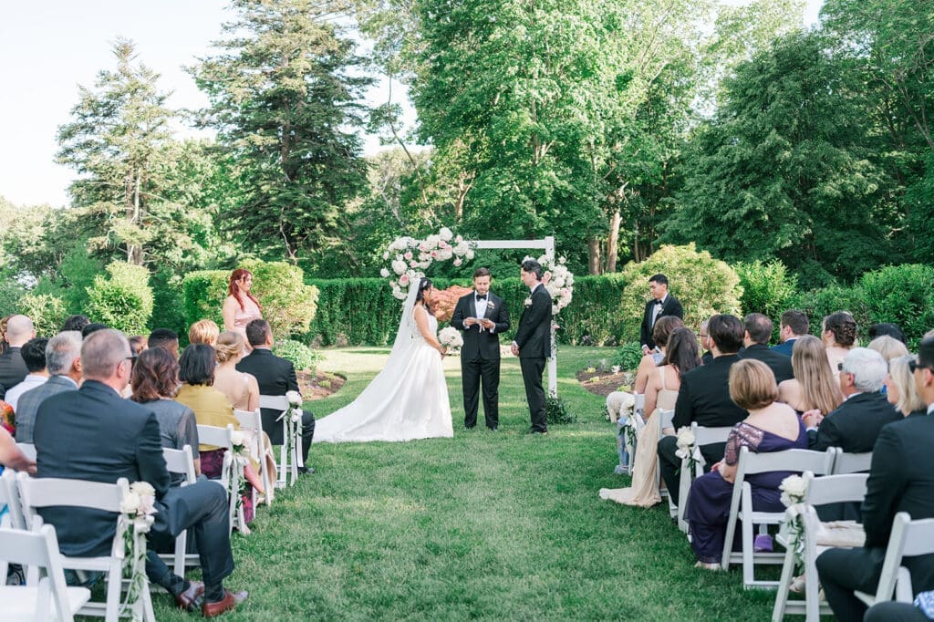 Emily and Chris face each other during their wedding ceremony. 