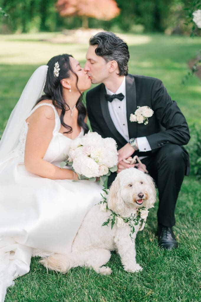 Emily and Chris kiss with their dog, Butter. 