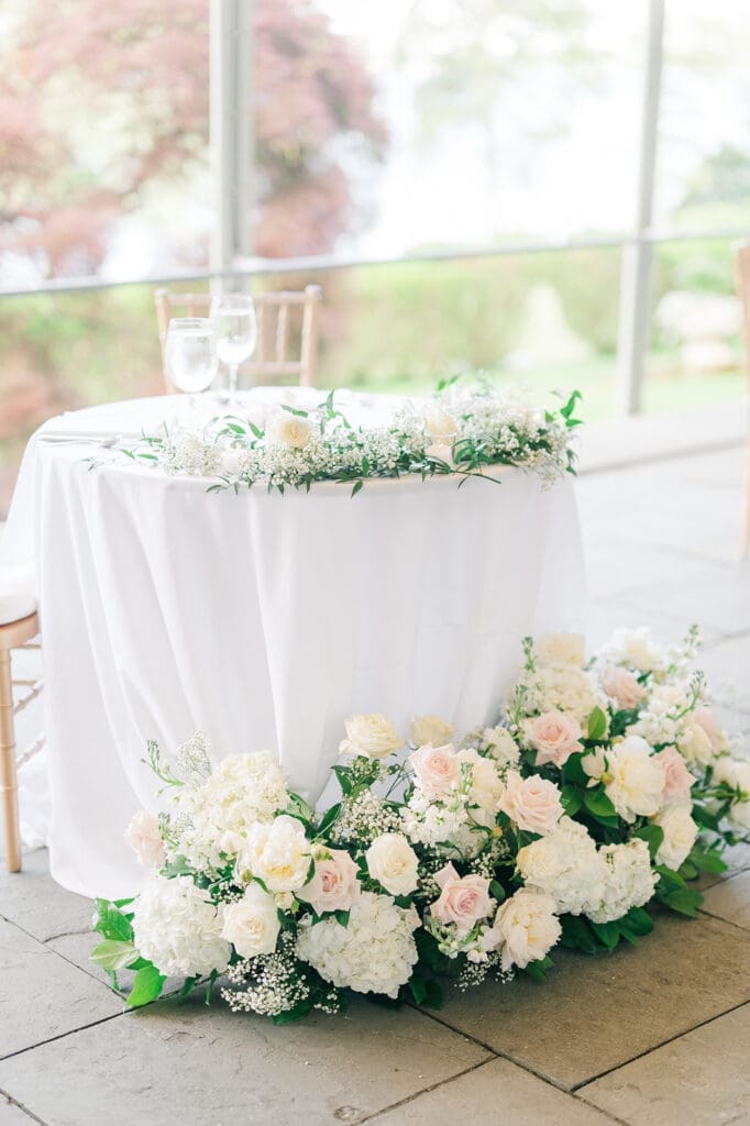 Florals surrounding the sweetheart table at a wedding reception