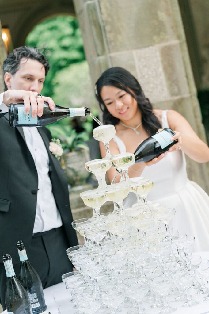 Emily and Chris pour a champagne tower for their wedding