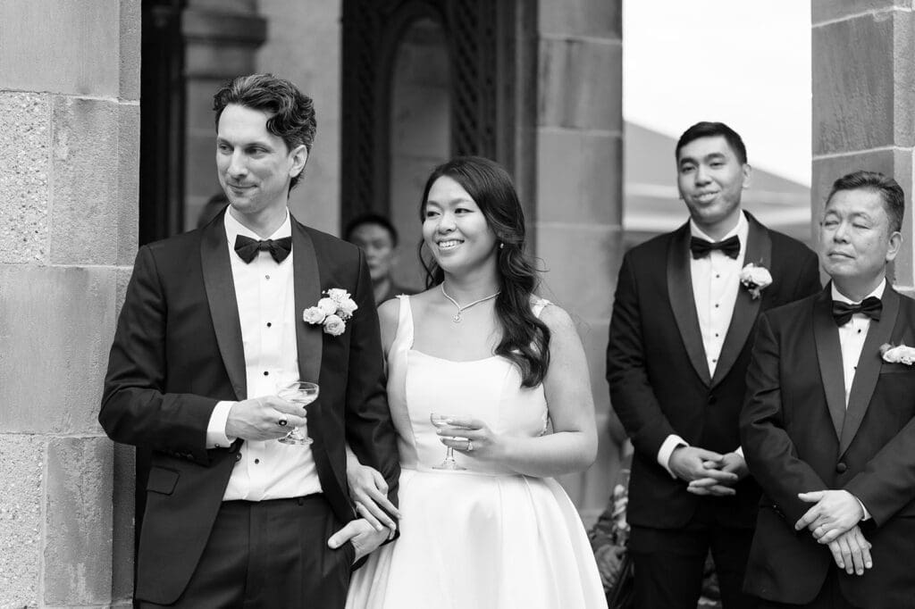 Emily and Chris smile as someone gives a speech
