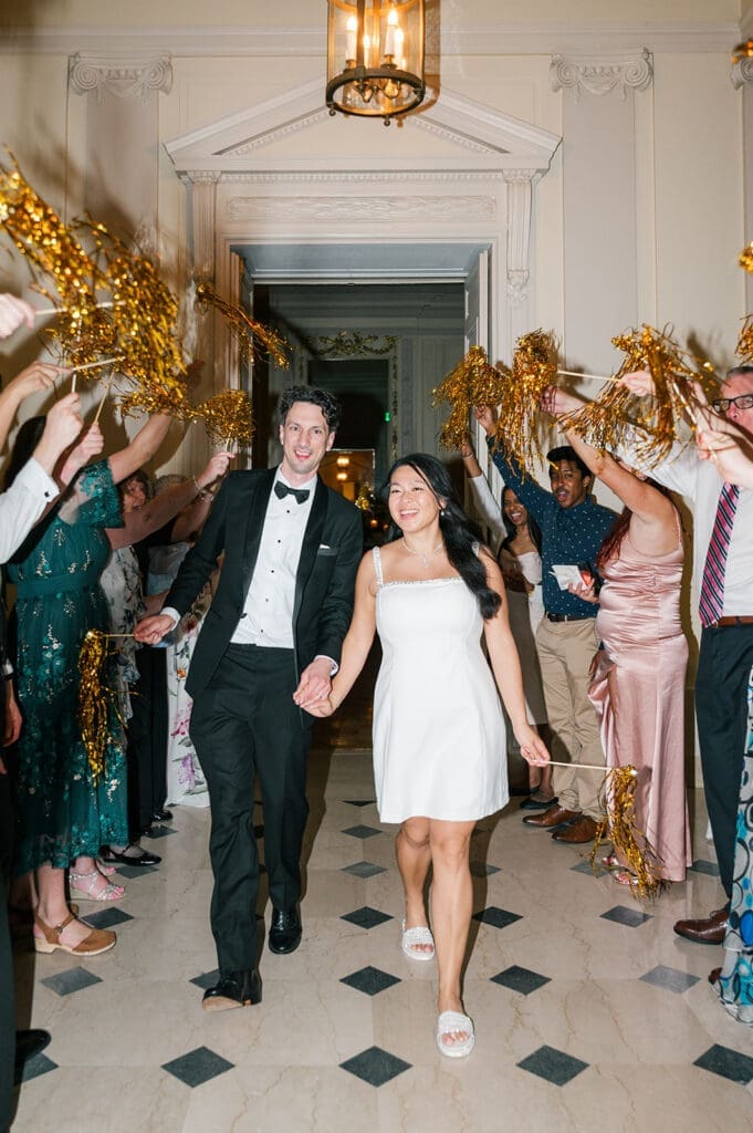 Emily and Chris stage an "exit" from their reception with pom poms