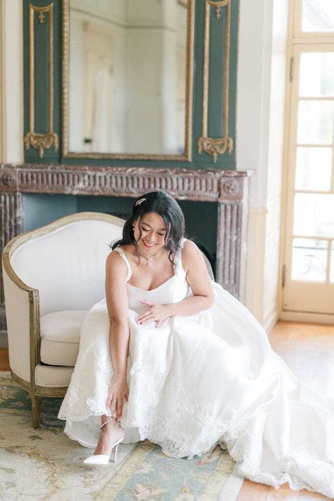 Emily adjusts her shoes while sitting on a chair in the Glen Manor bridal suite. 