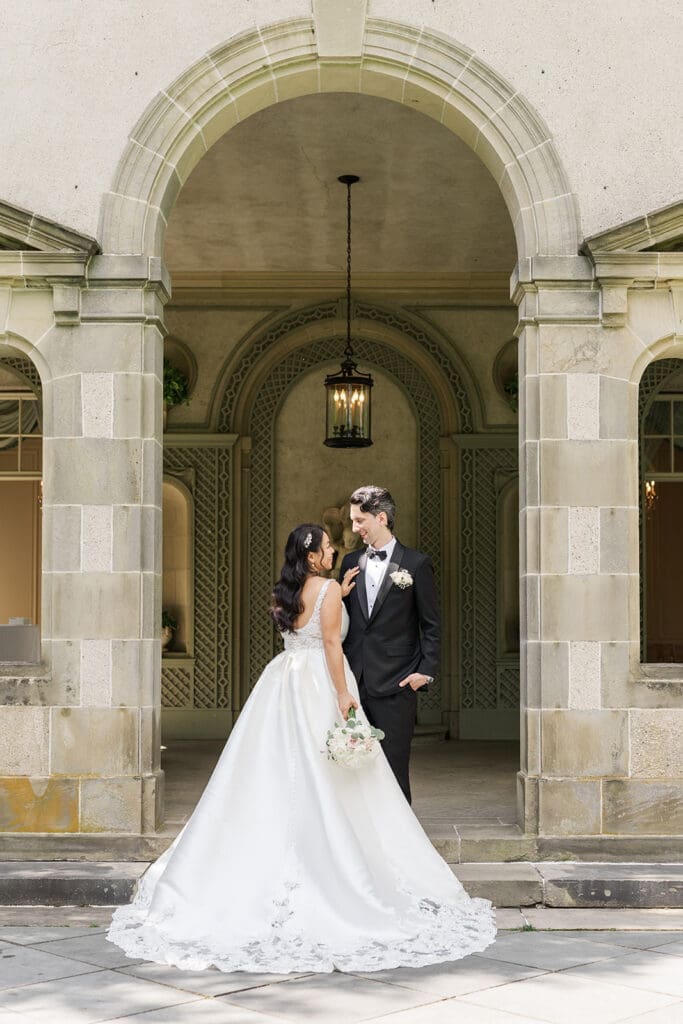 Emily and Chris smile together on the back steps of Glen Manor House. 