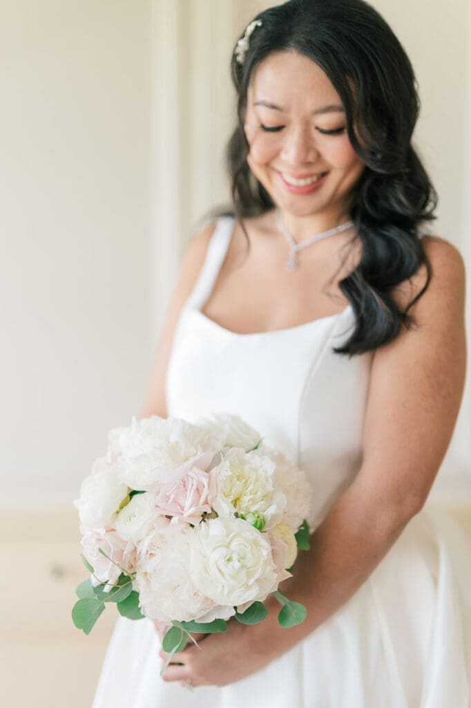 Emily smiles as she holds her bouquet 