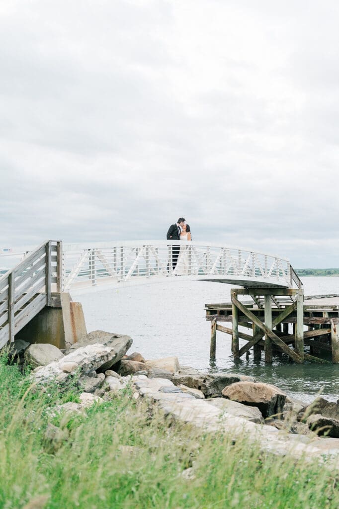 Emily and Chris kiss on the bridge at Glen Manor House