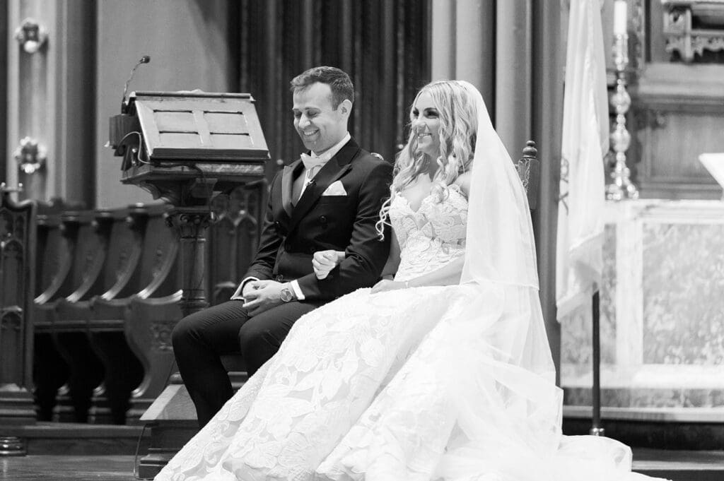 Jacquie and Thomas smile as they sit together on the altar. 