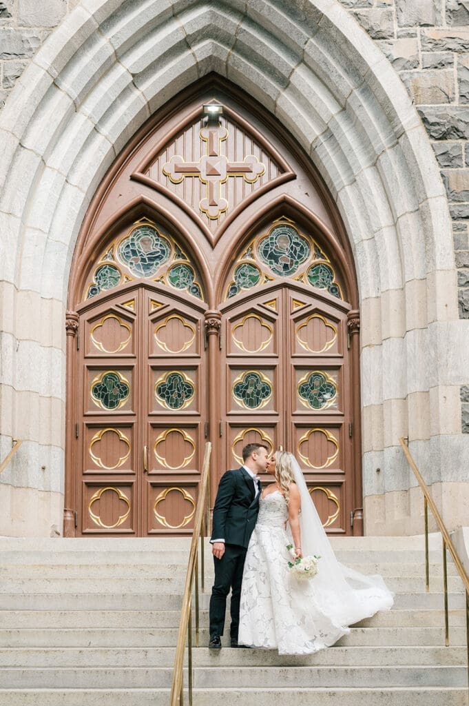 Thomas and Jacquie kiss on the front steps of St. Mary's Church. 