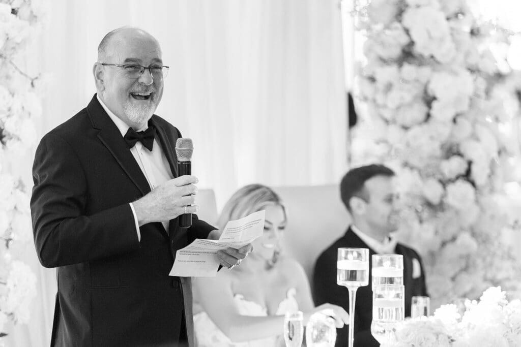 Jacquie's dad gives a speech at the reception. 