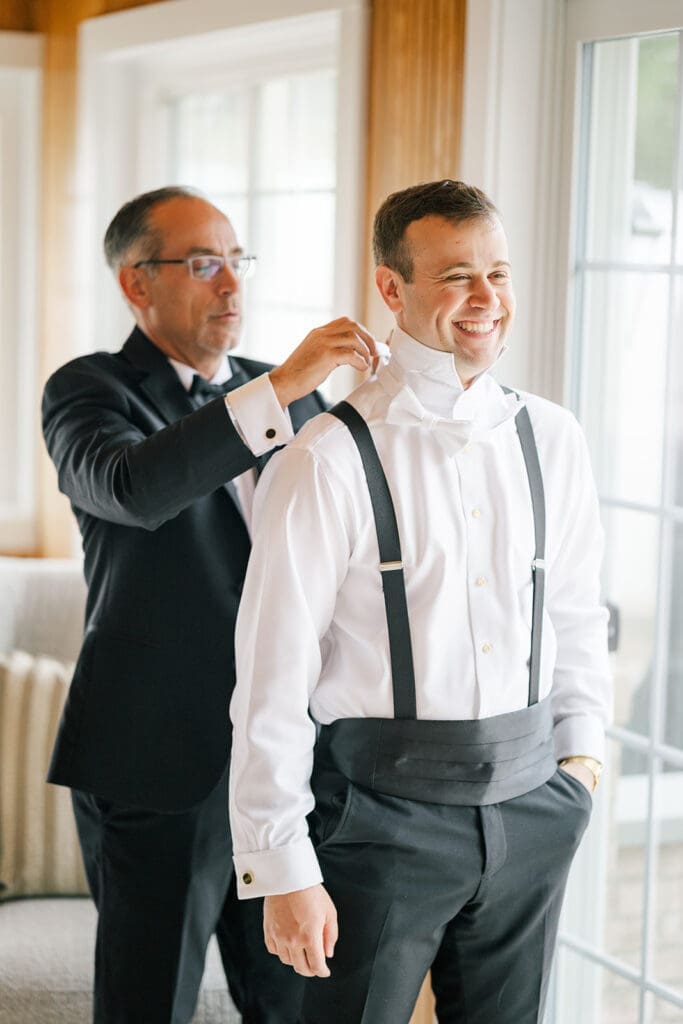 Thomas' dad helps put on his bowtie. 