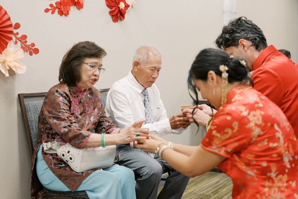 The couple hands tea cups to family members