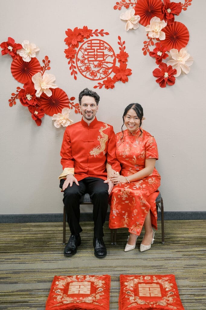 Emily and Chris sit in chairs as they get ready for their tea ceremony to begin
