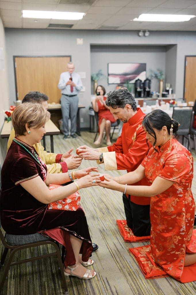 The couple hands the bride's parents tea cups