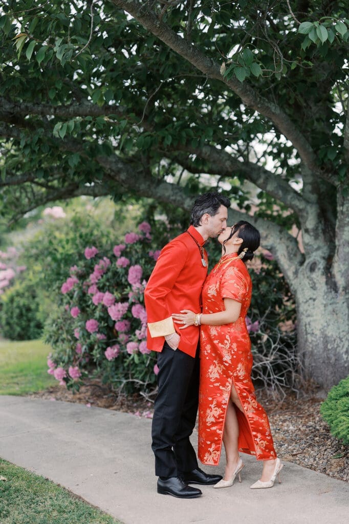Emily and Chris kiss under a tree after their Chinese Tea Ceremony. 