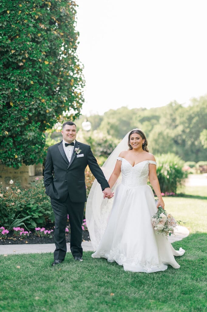 A wedding couple walking and holding hands outside of Saint Clements Castle