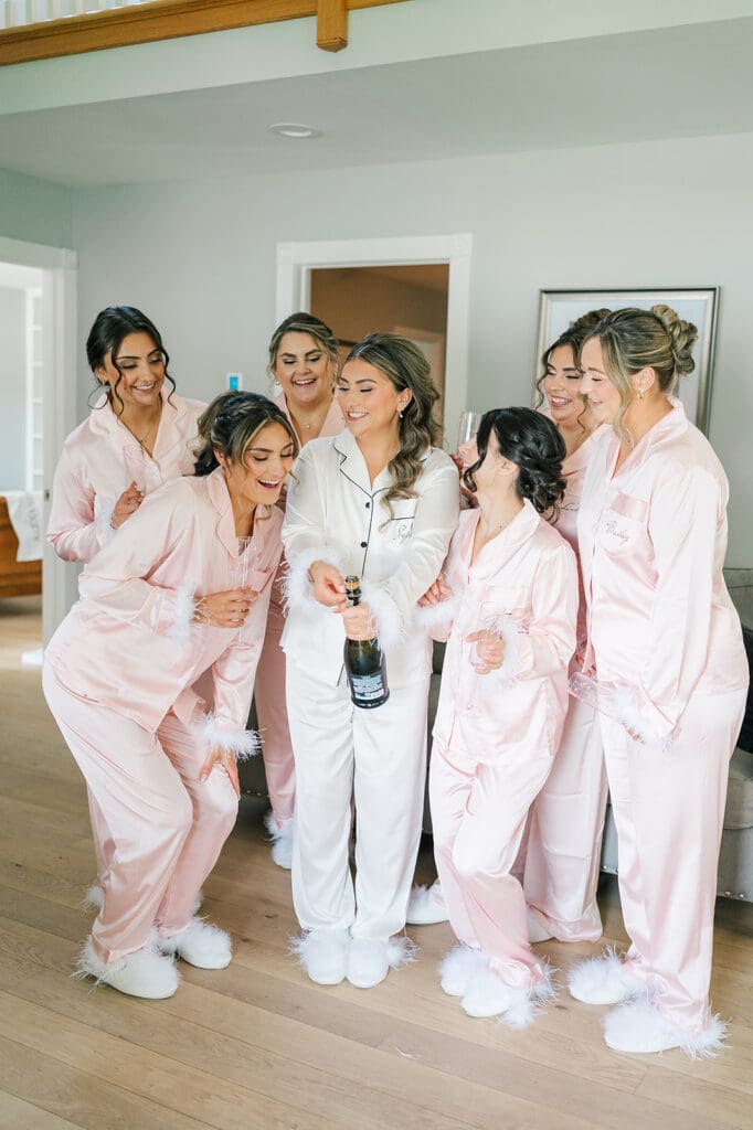 Sophie and her bridesmaids popping champagne for her wedding