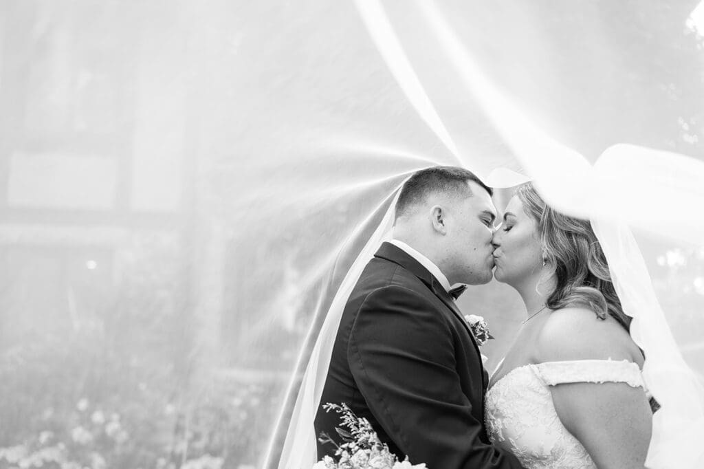 Sophie and John kiss under the wedding veil at their Saint Clements Castle Wedding