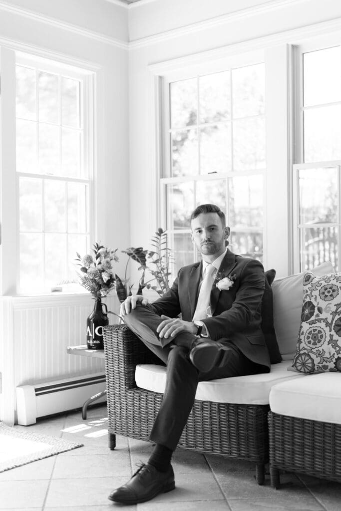 Conor sits and smiles softly before his Wampanoag Country Club Wedding.