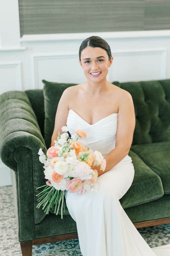 Amy holds her bouquet and smiles at her Wampanoag Country Club Wedding