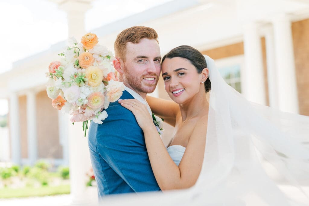 Amy and Conor smile and touch heads as Amy's veil flies in front of them