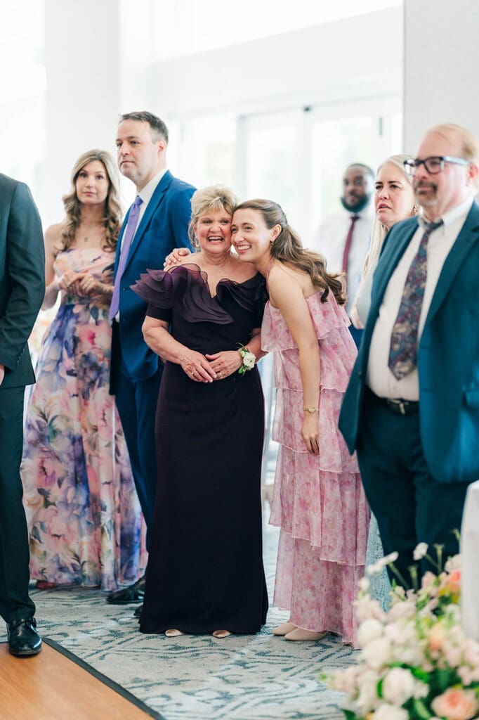 Amy's mom and sister smile together as they watch dancing.