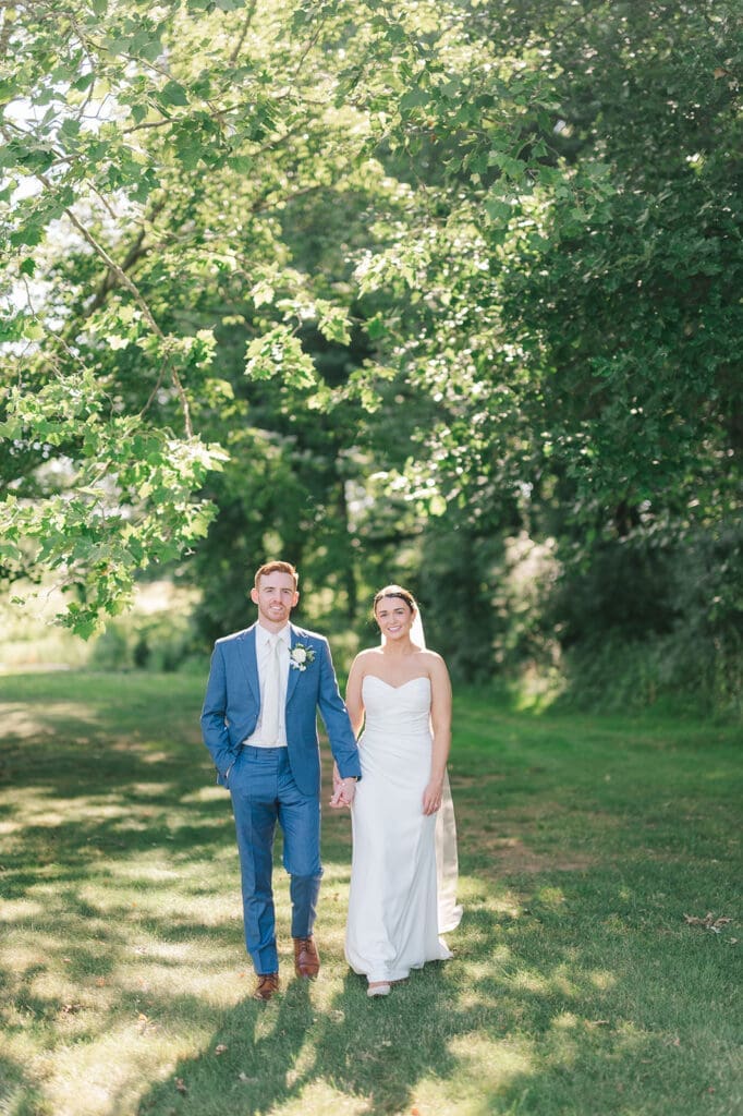 Amy and Conor walk and hold hands at their Wampanoag Country Club Wedding.