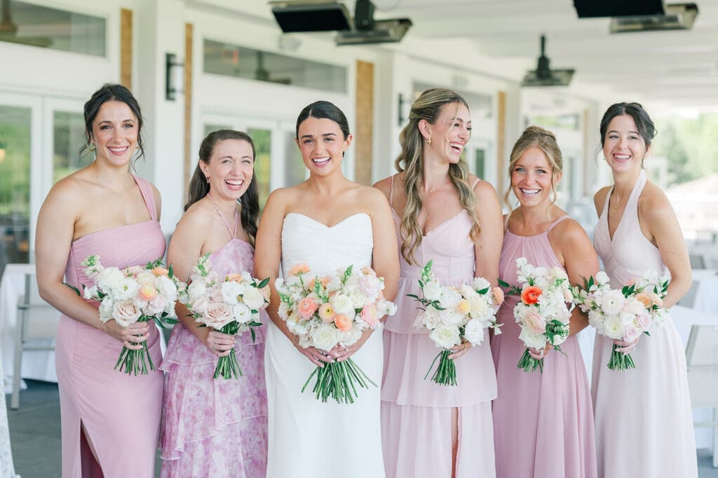Amy and her bridesmaids smile and stand together 