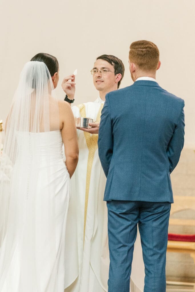 Amy and Conor receive the Eucharist at their Catholic wedding ceremony