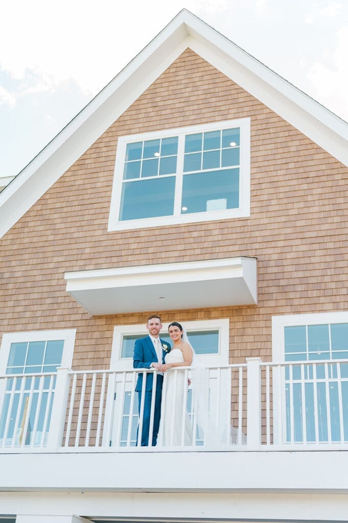 Conor and Amy stand on a balcony at their Wampanoag Country Club Wedding