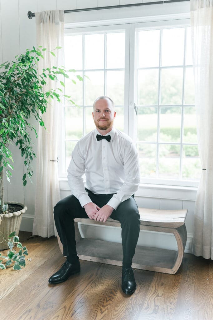 Kevin sits on a seat and smiles.