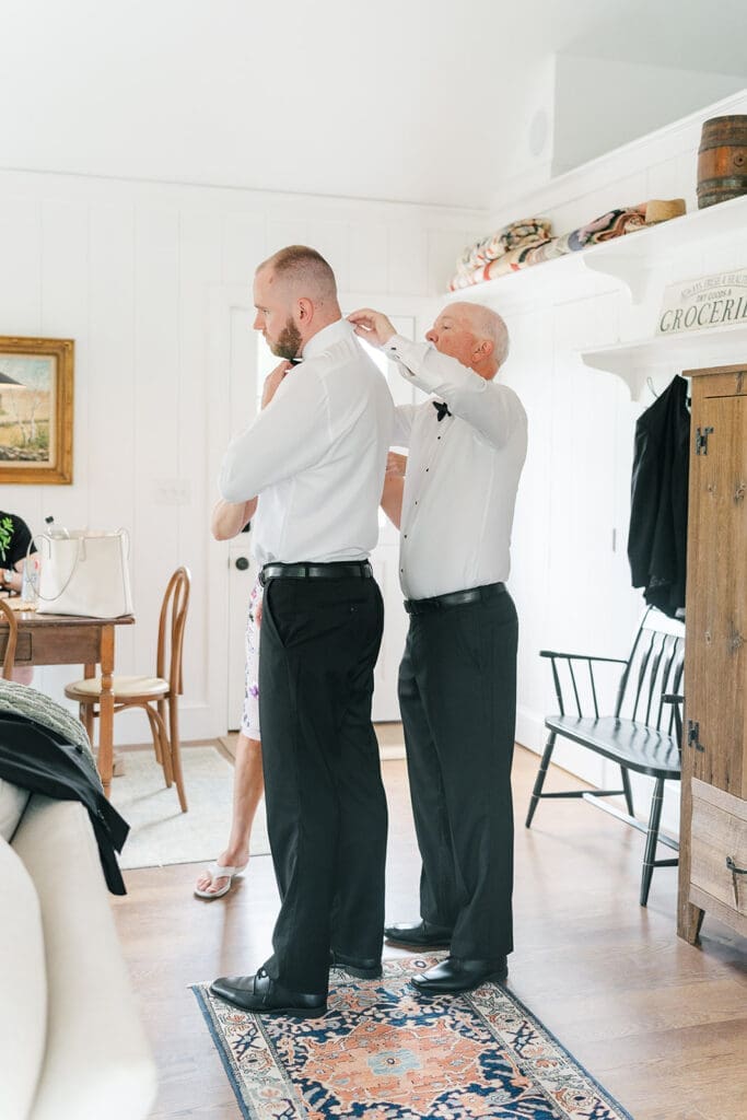 Kevin puts on his bowtie with his dad in the guest house at Smith Farm Gardens.