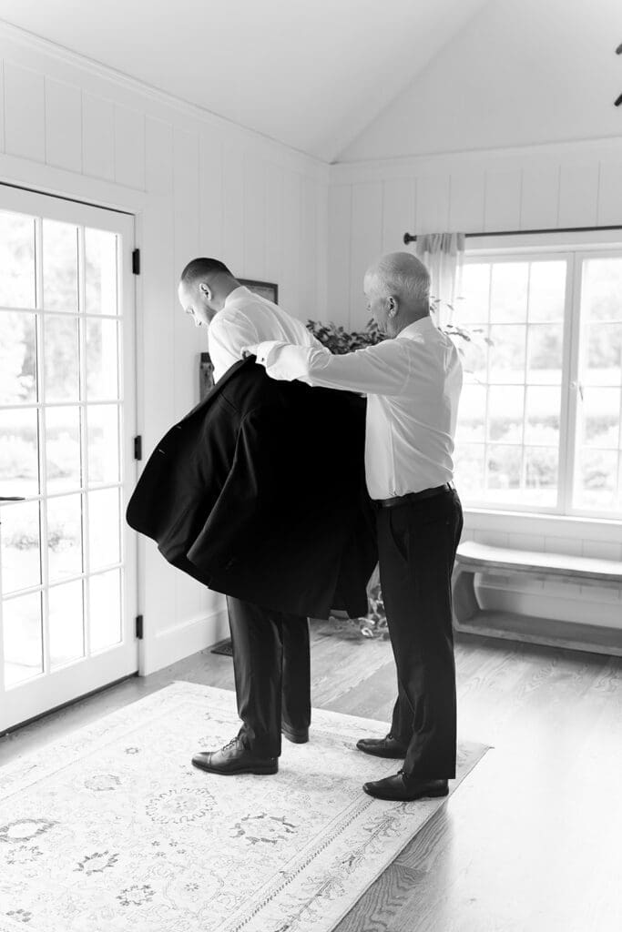 Kevin puts on his jacket in the guest house at Smith Farm Gardens.