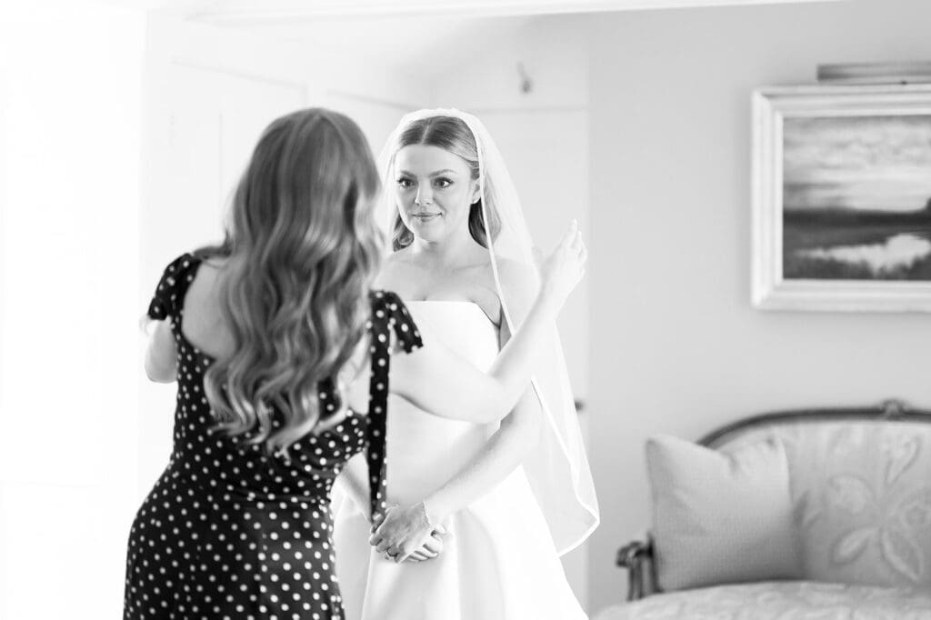 Georgia smiles as her sister puts on her veil for her.