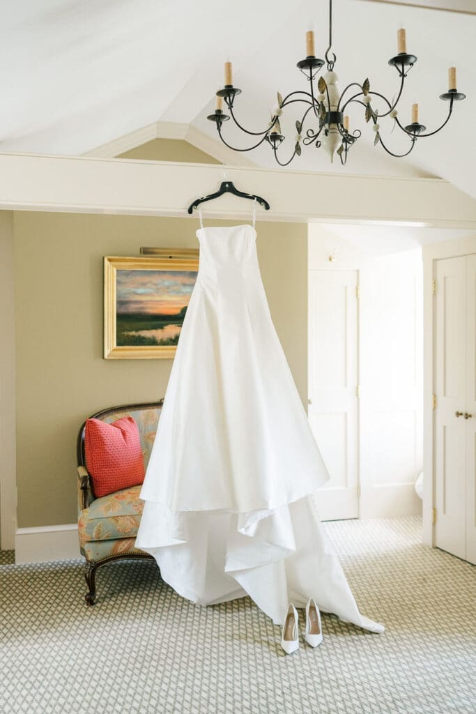 a wedding dress hangs from a beam in the bridal suite in Smith Farm Gardens.