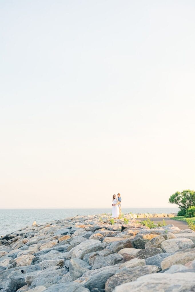 Rich and Lindsey stand on the pier of rocks in Westport for their maternity photoshoot in CT