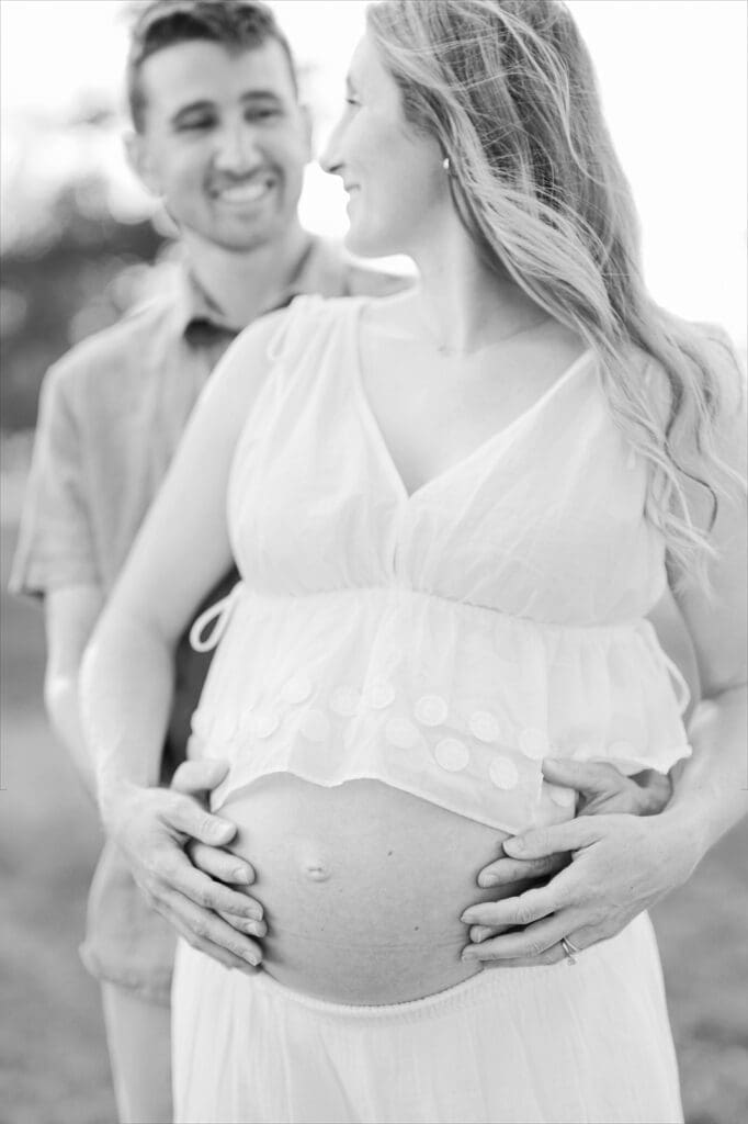 Rich and Lindsey caress her belly with their hands.