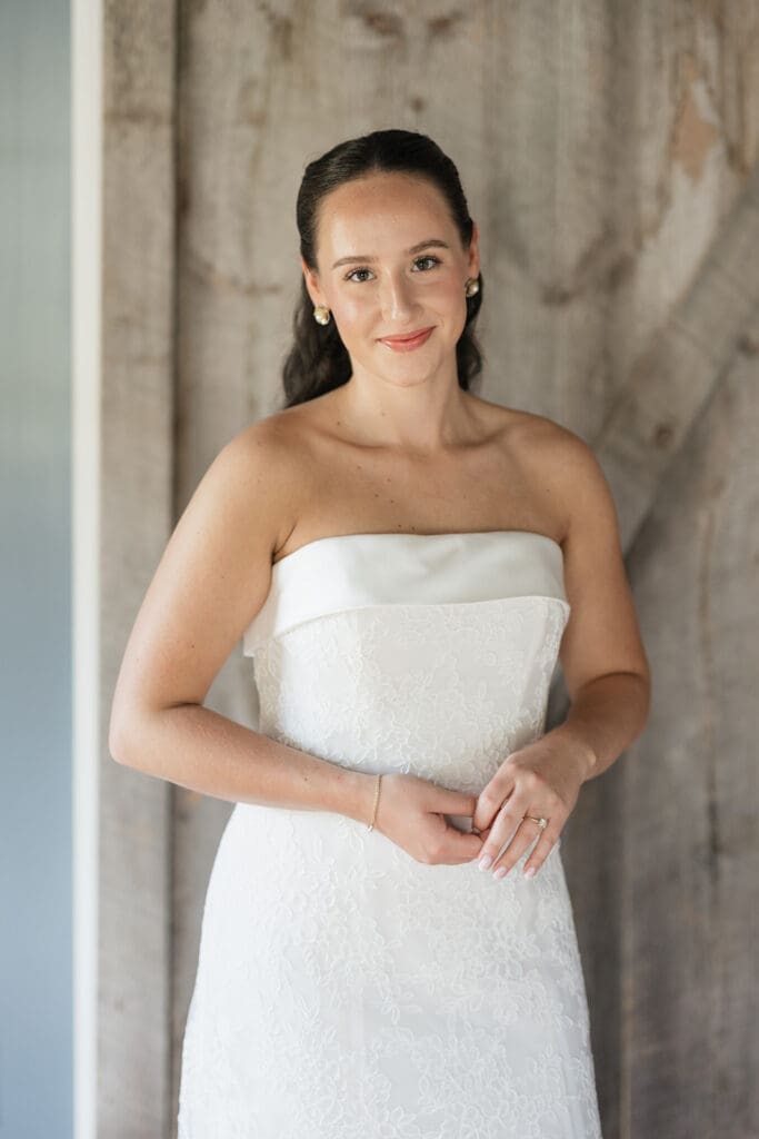 A bride softly smiles for a portrait in her dress. 