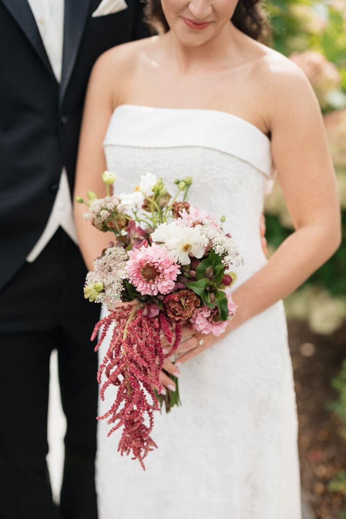 A bride holds her colorful bouquet. 