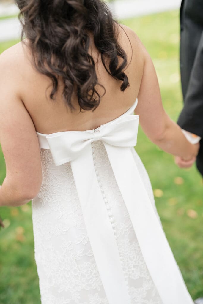 The back of a bride's wedding dress with a long flowy bow. 