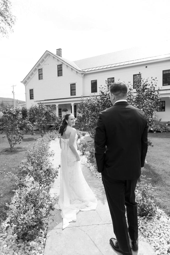 A bride laughs and smiles as she walks ahead of her groom. 